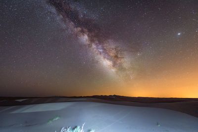 Scenic view of snow covered landscape against sky at night