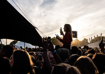 Crowd at music concert against sky