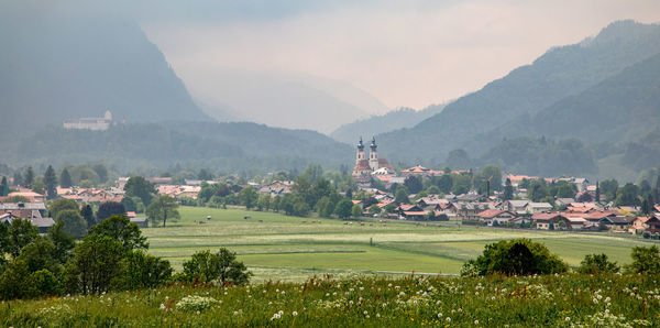 Scenic view of townscape by mountains against sky