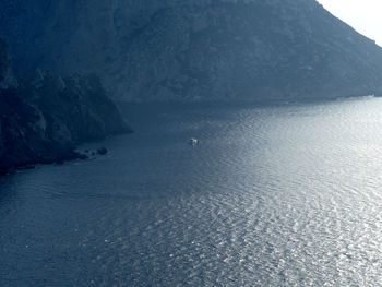 View of calm sea against mountain range