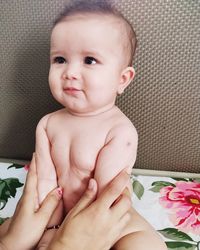 Cute baby girl lying on bed at home