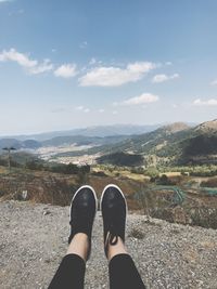 Low section of man on landscape against sky