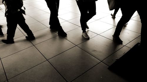 Low section of people standing on tiled floor