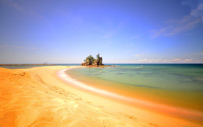 Scenic view of beach against blue sky