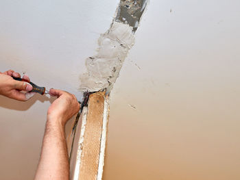 Close-up of woman hand against white wall