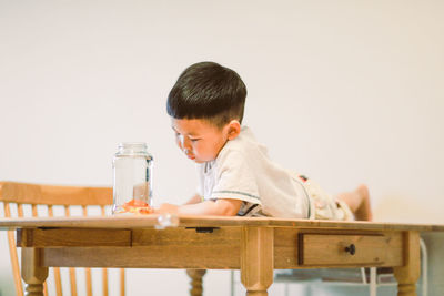 Boy looking at sitting on table
