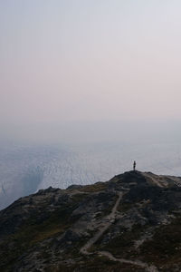 Full length of man standing by cliff against sea