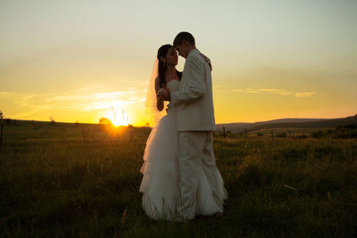 Couple on field during sunset