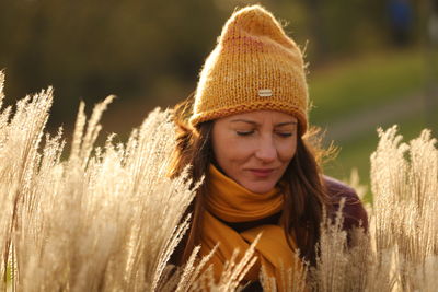 Portrait of beautiful young woman in hat on field