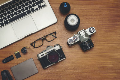 High angle view of camera and laptop on table