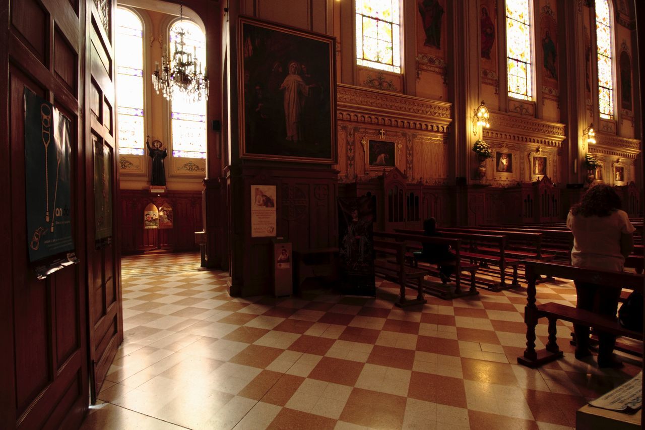 flooring, architecture, built structure, indoors, tiled floor, seat, tile, building, religion, place of worship, real people, spirituality, illuminated, belief, chair, women, table, empty