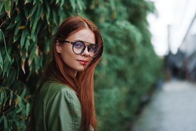 Portrait of young woman wearing sunglasses standing outdoors