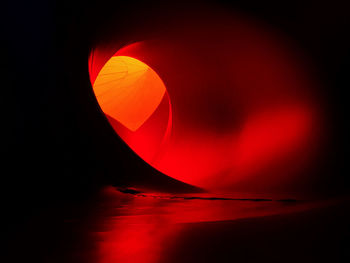 Close-up of illuminated red light against sky at night