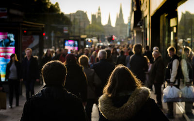Rear view of people standing on street in city