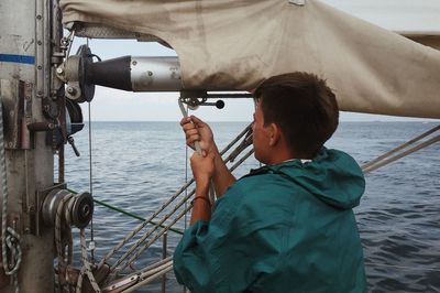 Rear view of man photographing in sea