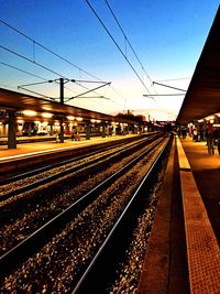 Train at railroad station against sky during sunset