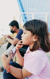 Women looking at camera while sitting on mobile phone