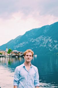 Portrait of young man against lake and mountains