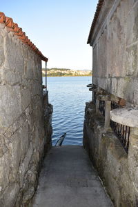 View of old building by sea against clear sky