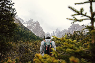 Rear view of person on snow covered mountains against sky