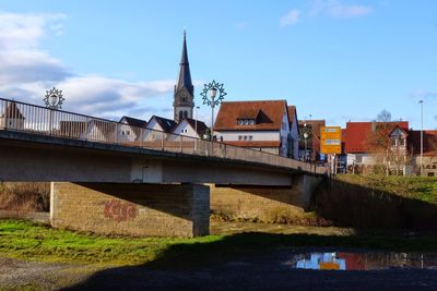 Bridge over river against buildings in city