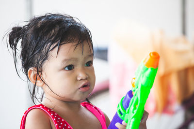 Close-up of cute baby girl holding squirt gun