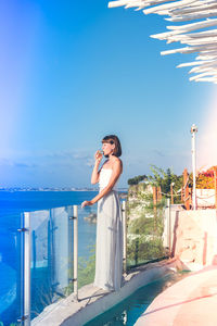 Woman standing against blue sky