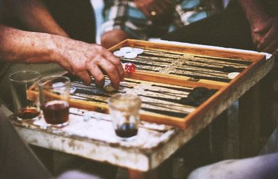 Midsection view of men playing backgammon