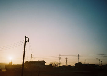 Silhouette electricity pylon against sky during sunset