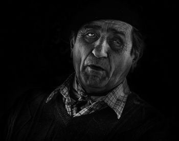 Close-up portrait of man against black background