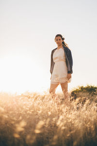 Woman standing on field against clear sky