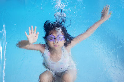 Portrait of cute girl swimming in pool