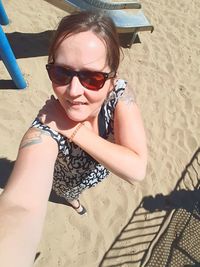 High angle view of boy wearing sunglasses on sand at beach