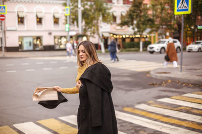 Portrait of young woman standing in city