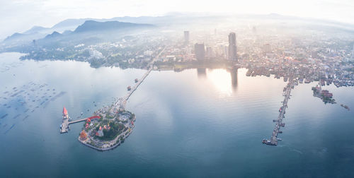 Aerial view of buildings in city against sky during sunset