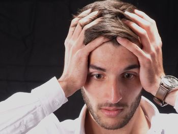 Close-up portrait of young man against black background
