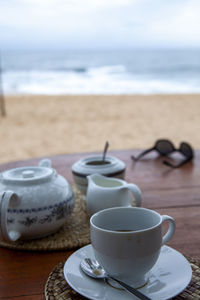 Coffee cup on table by sea