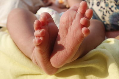 Low section of newborn lying on bed