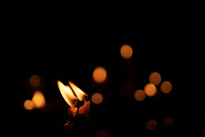 Candles and lights on a black background with bokeh lights.