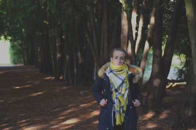 Portrait of smiling young woman standing in forest