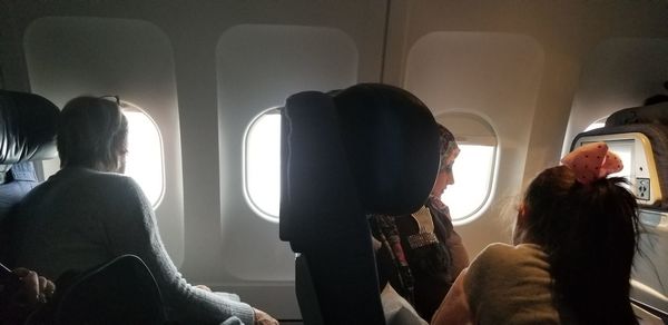 Rear view of woman sitting in airplane