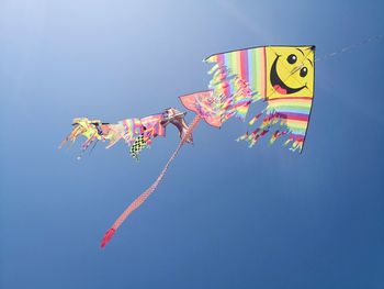 Low angle view of kite flying against clear blue sky