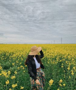 Person standing on yellow flower field