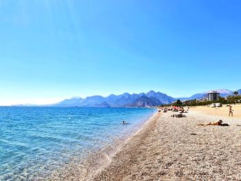 Scenic view of beach against clear blue sky