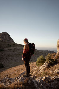 Full length of man standing on rock against sky