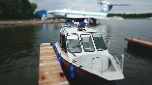 Close-up of boat sailing on lake against sky