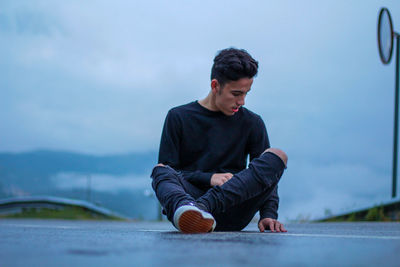 Boy sitting against sky