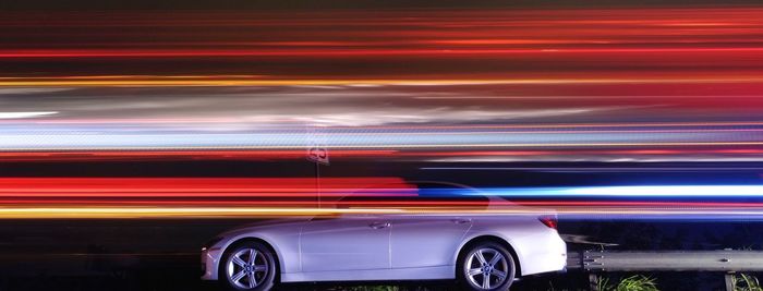 Light trails against car on street