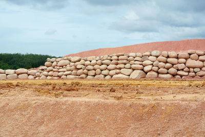 Stone wall on field against sky