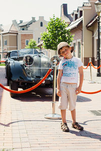 Full length portrait of boy standing in city